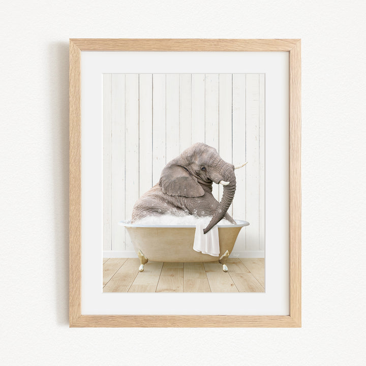 A gray elephant is sitting in a bathtub filled with water, with its trunk raised and appearing to be enjoying the bath.