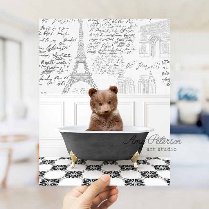 a person holding a card with a picture of a teddy bear in a bathtub