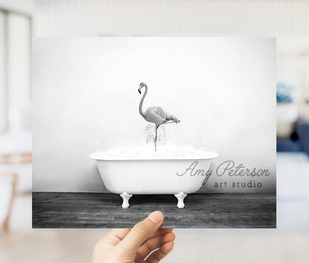 a person holding up a picture of a flamingo in a bathtub