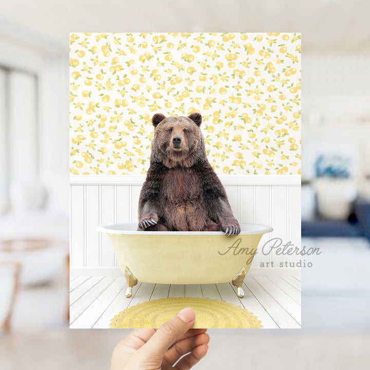 a person holding up a picture of a bear in a bathtub