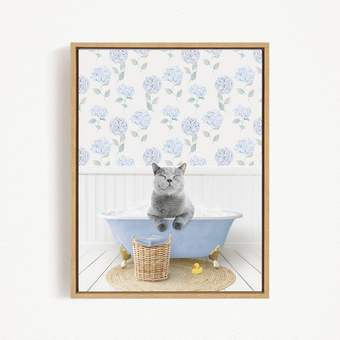 A gray cat sitting in a blue bathtub filled with water, surrounded by a wicker basket and rubber duckies.