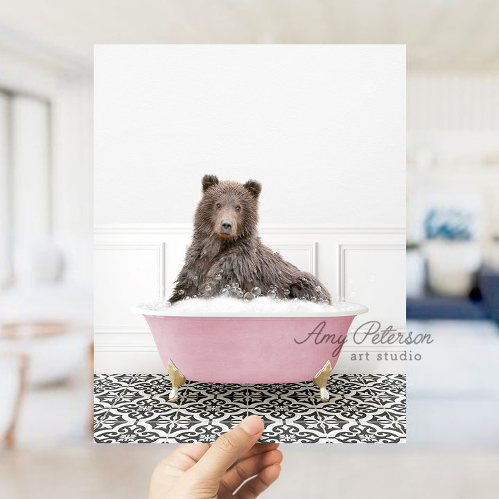 a hand holding a card with a picture of a bear in a bathtub