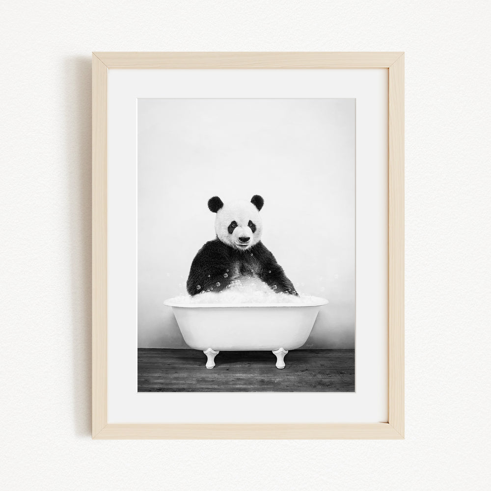 A panda bear sitting in a white bathtub filled with bubbles, creating a whimsical and playful scene.