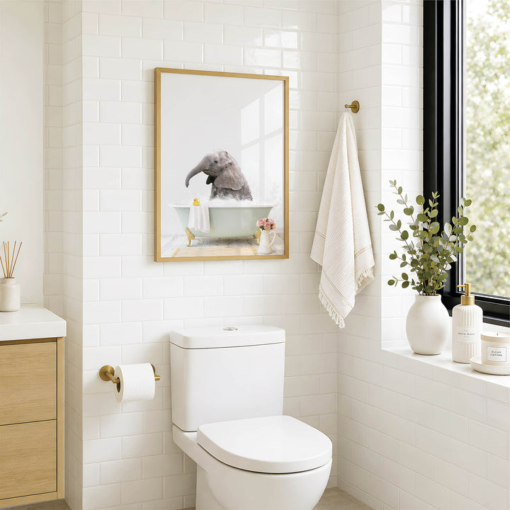 A modern bathroom with a white toilet, a framed picture of a bird in a bathtub, and a window with greenery on the sill.
