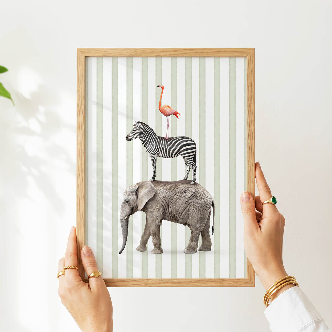 A person's hands are holding a framed picture of an elephant standing on a zebra.
