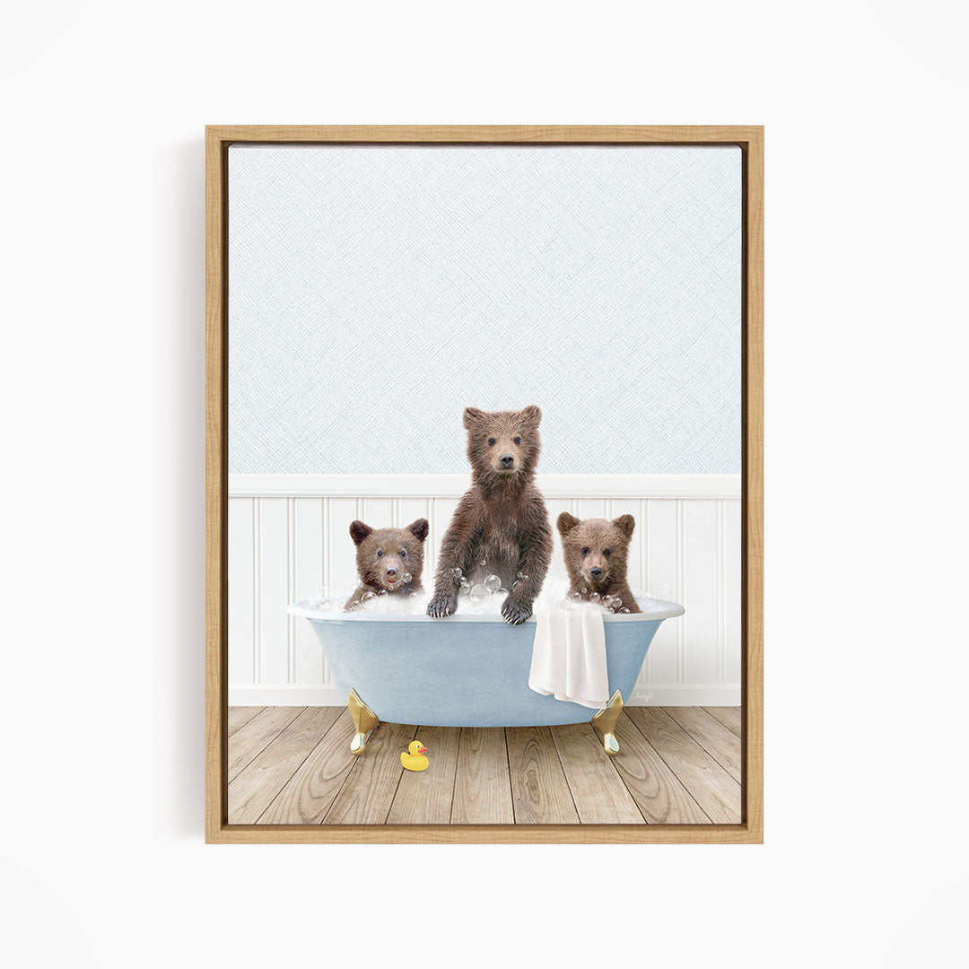 A framed image depicting three brown bears sitting in a blue bathtub, with one bear sitting on the edge of the tub and the other two bears sitting inside the tub.