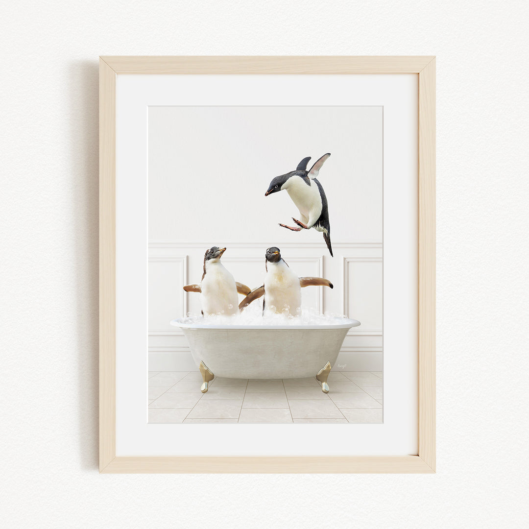 A framed image depicting two penguins sitting in a bathtub, with one penguin flying towards the other penguin.
