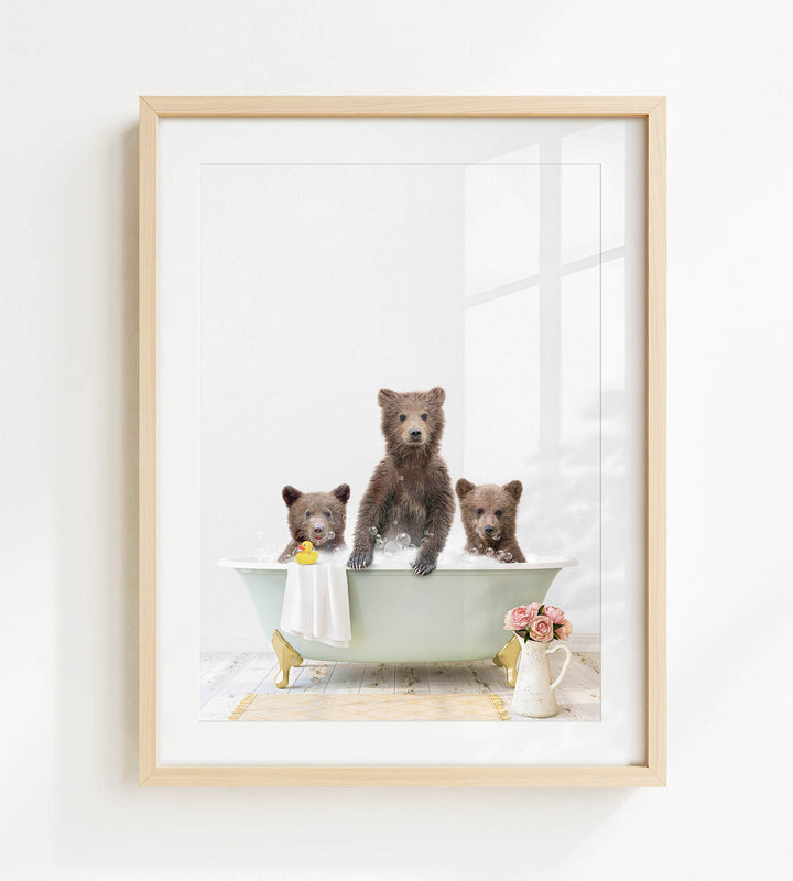A framed image depicting three brown bears sitting in a bathtub, with one bear sitting on the edge of the tub and the other two bears sitting inside the tub.