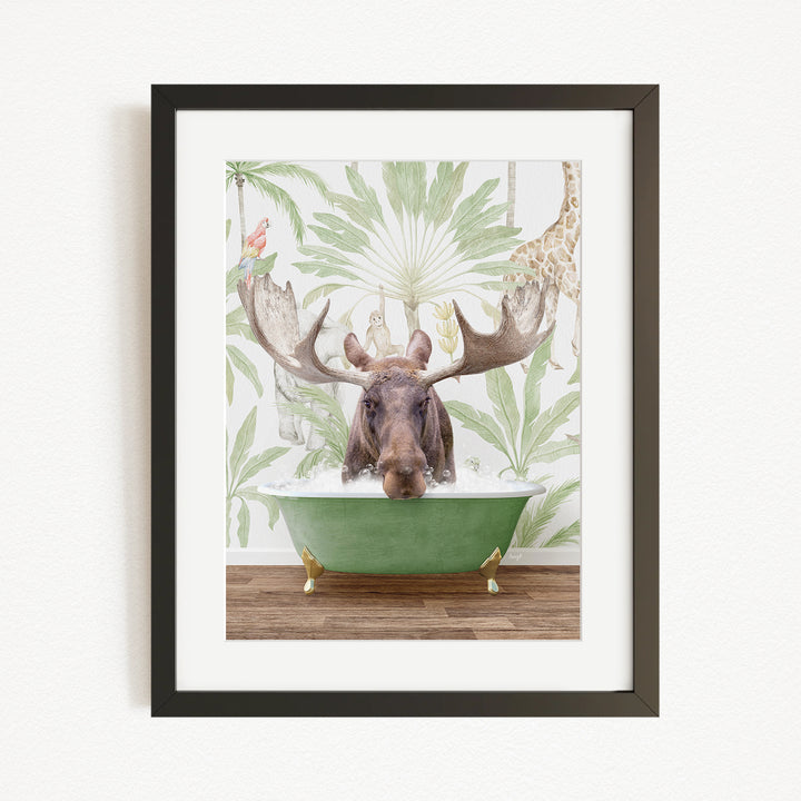 A moose with large antlers is sitting in a green bathtub, surrounded by a tropical wallpaper with palm leaves and a giraffe.