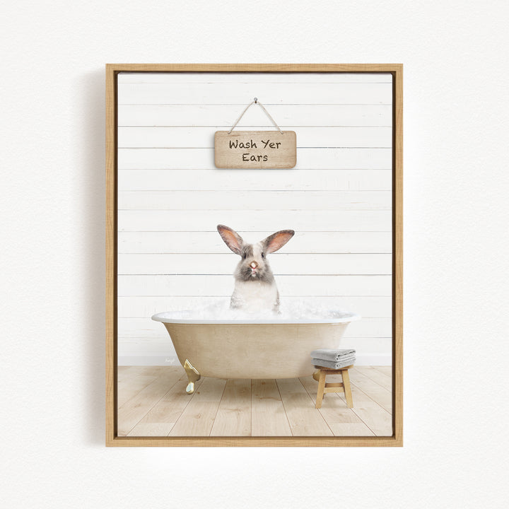 A framed image depicting a rabbit sitting in a bathtub, with a sign above that reads "Wash Your Ears".
