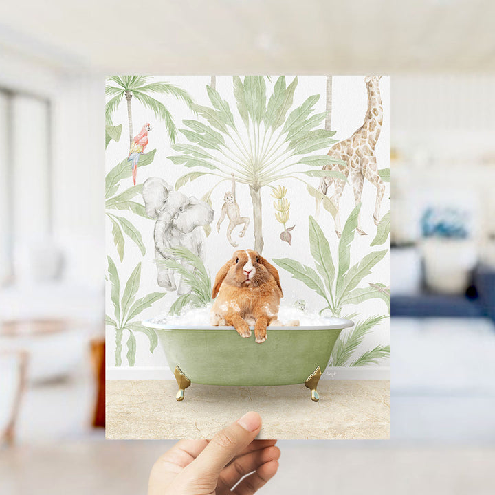 A hand holds up a print featuring a whimsical scene of a rabbit sitting in a bathtub surrounded by various animals, including a giraffe, elephant, and parrot, all set against a tropical jungle backdrop.