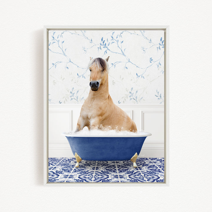 A light brown horse is sitting in a blue bathtub filled with water, surrounded by a blue and white patterned rug.