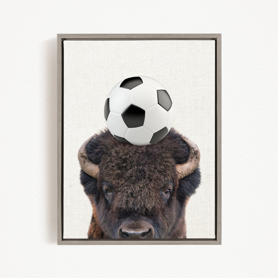 A buffalo with a soccer ball on its head.