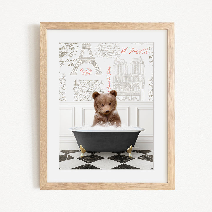 A cute brown bear sitting in a bathtub filled with bubbles, surrounded by a checkered floor and a framed picture of the Eiffel Tower in the background.