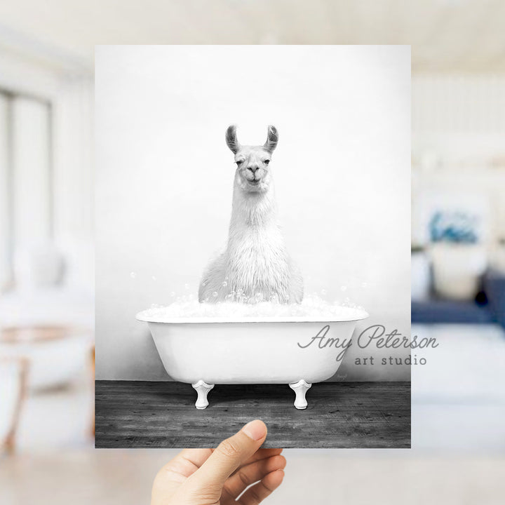 a person holding up a card with a picture of a llama in a bath