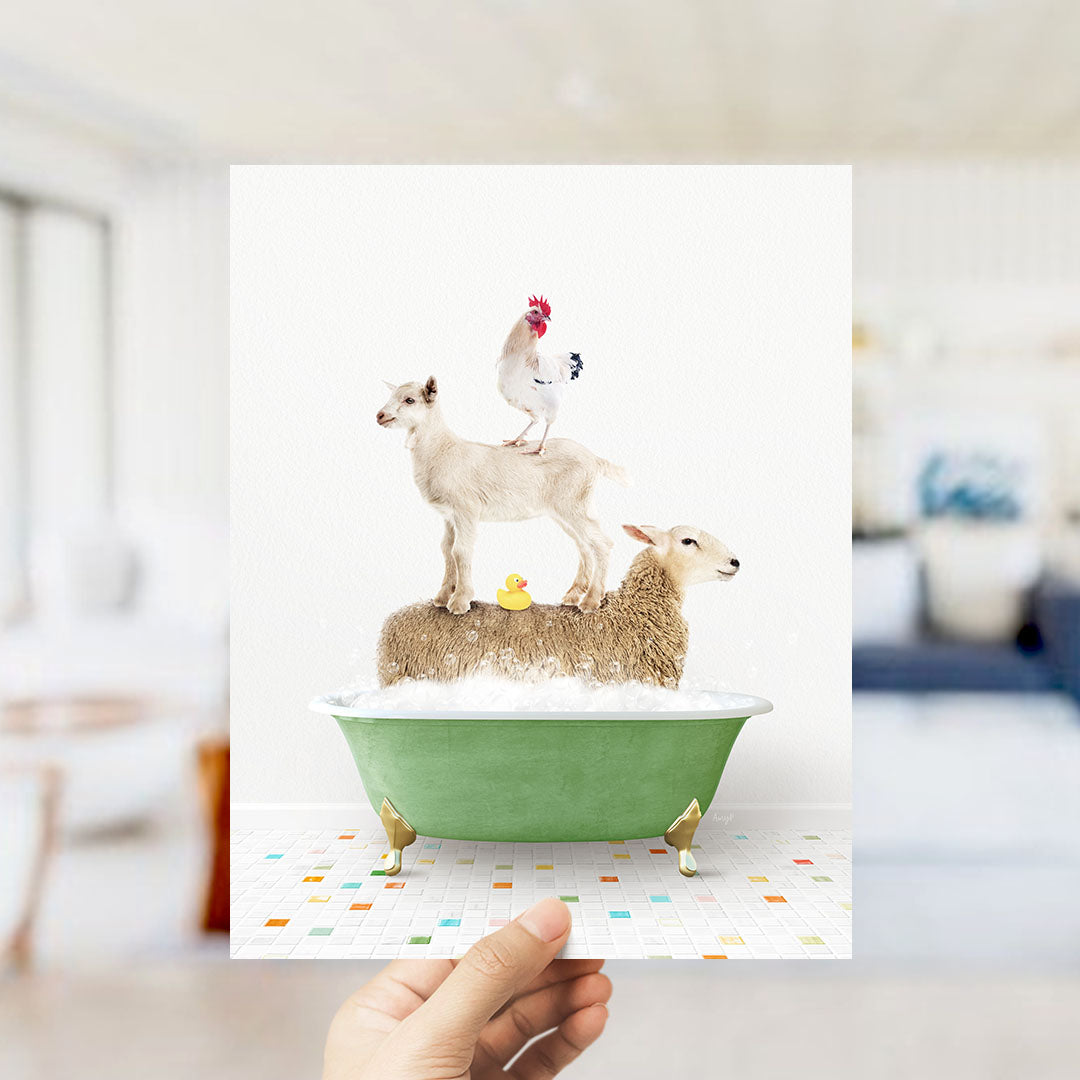 A hand holds up a framed image depicting a goat standing on a sheep's back while a chicken sits on top of a sheep in a bathtub.