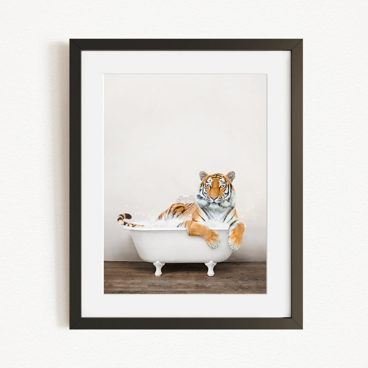 A tiger is sitting in a white bathtub, appearing relaxed and enjoying the bath.