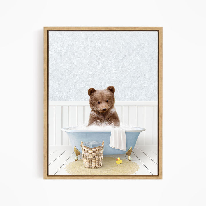 A brown bear sitting in a blue bathtub filled with bubbles, surrounded by a yellow rubber duck and a basket.