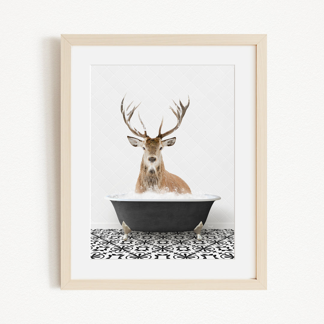 A deer with large antlers is sitting in a black bathtub filled with water, creating a whimsical and unexpected scene.