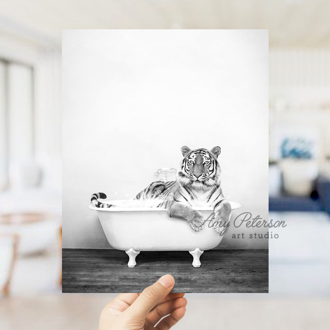 a hand holding up a black and white photo of a tiger in a bathtub