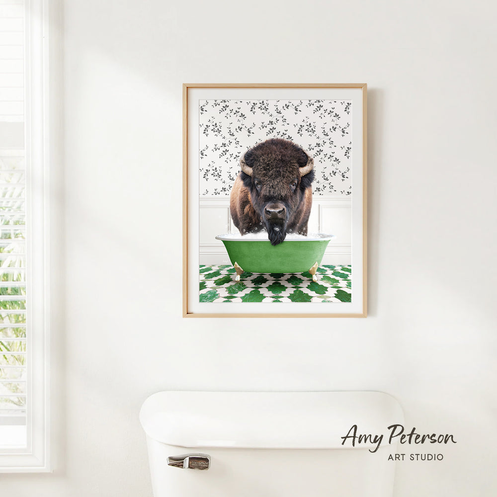 A framed image of a buffalo standing in a green bathtub, with a patterned wall behind it.