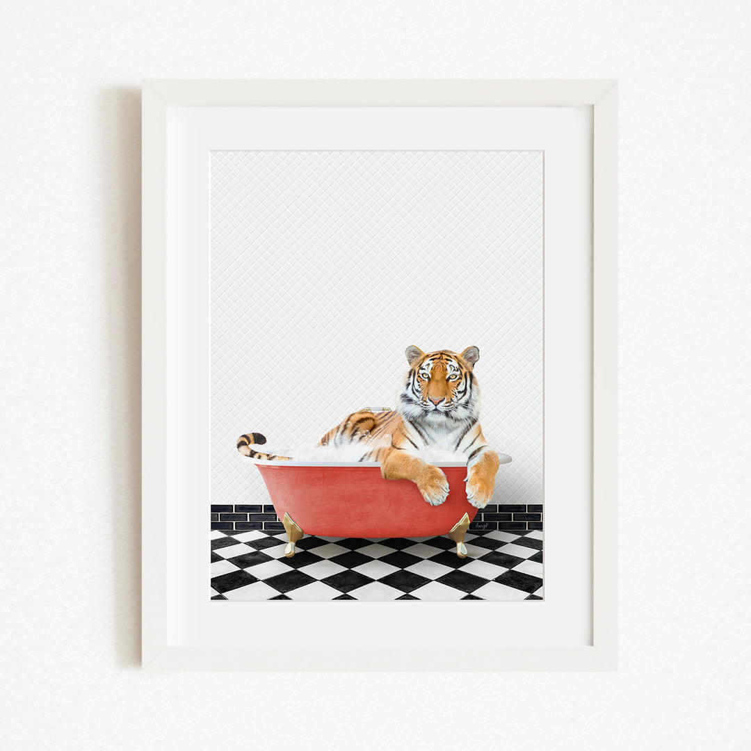 A tiger is sitting in a red bathtub on a black and white checkered floor.