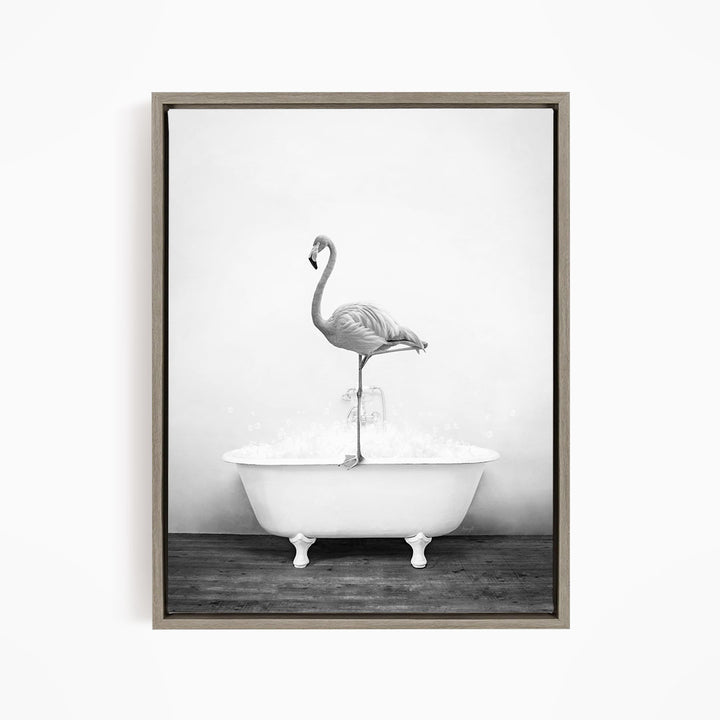 A black and white photograph of a flamingo standing on the edge of a white bathtub filled with water.