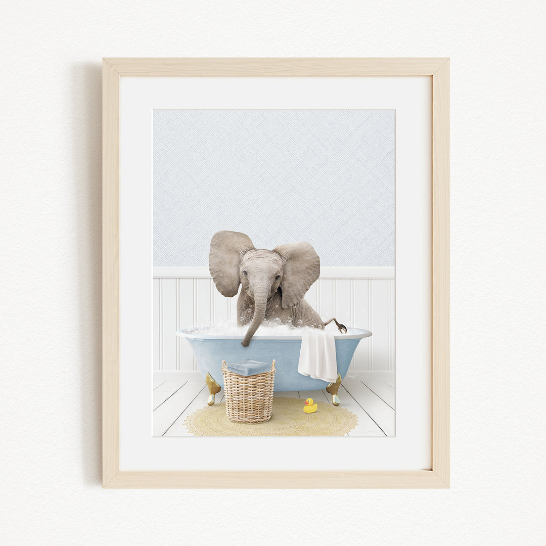 A baby elephant sitting in a blue bathtub, surrounded by a yellow rubber duck and a basket of toys.