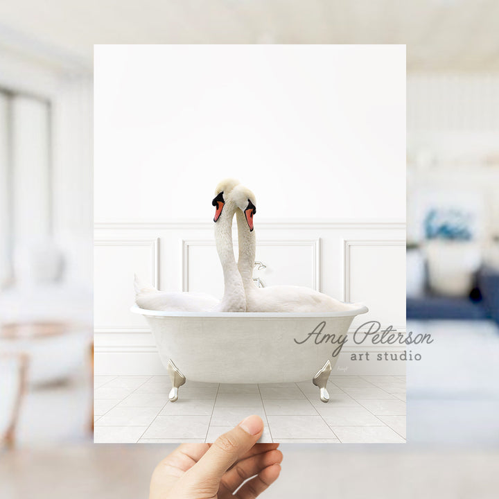 a person holding up a picture of a swan in a bathtub