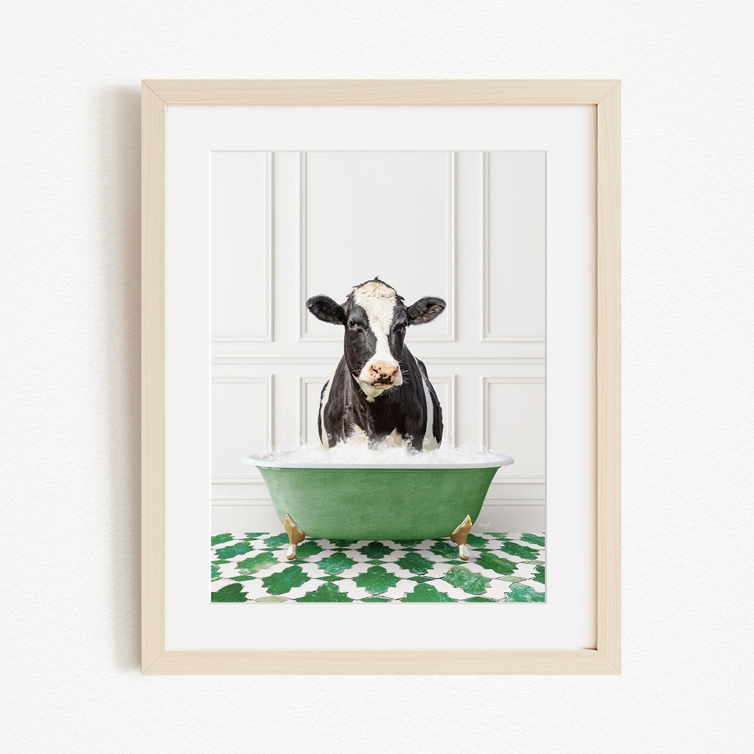 A black and white cow is sitting in a green bathtub filled with water, creating a whimsical and playful scene.