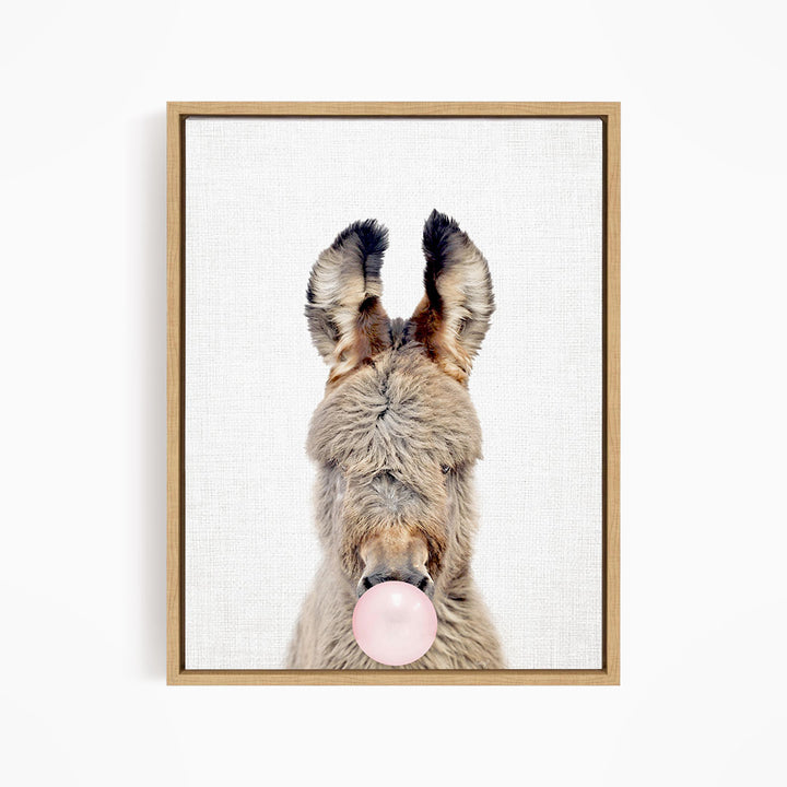 A donkey blowing a bubble with a pink bubble gum bubble.