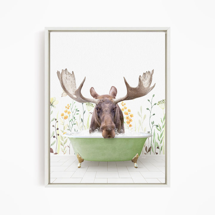 A moose with large antlers is sitting in a green bathtub, surrounded by flowers and plants.