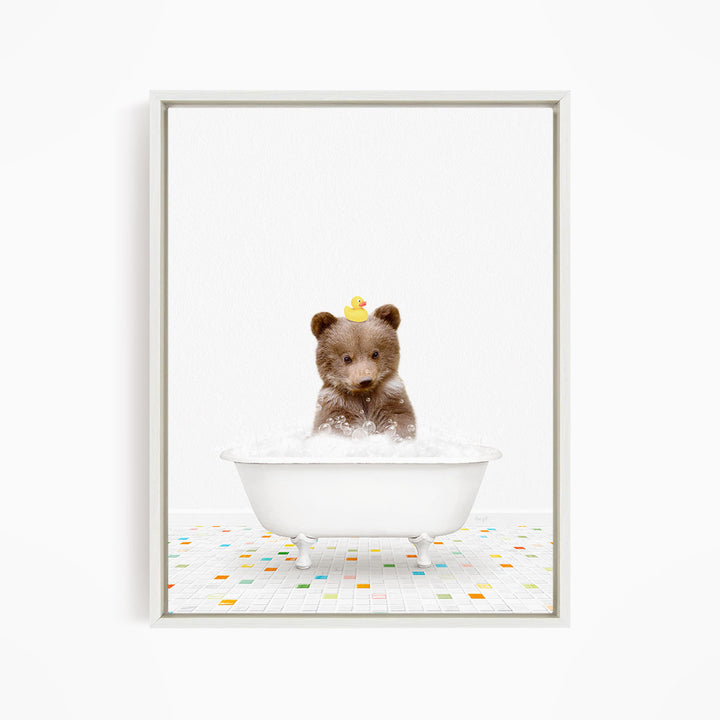 A cute brown bear sitting in a white bathtub filled with bubbles, with a yellow rubber duck perched on its head.