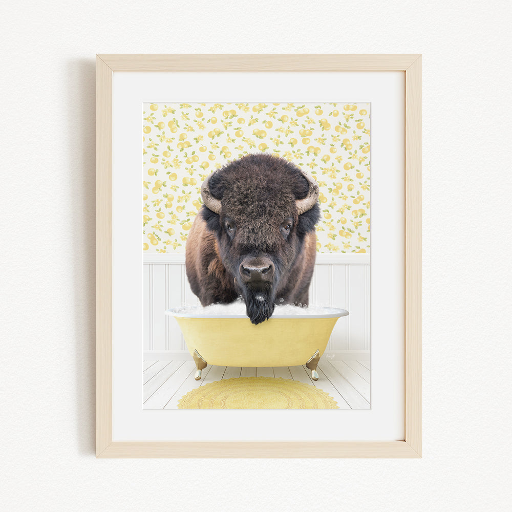 A buffalo standing in a yellow bathtub, with a yellow floral pattern on the wall behind it.