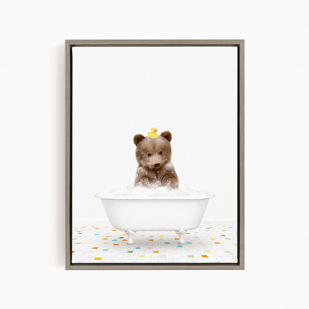 A cute brown bear sitting in a white bathtub filled with bubbles, wearing a yellow rubber duck on its head.