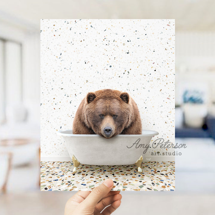 a hand holding up a card with a bear in a bathtub