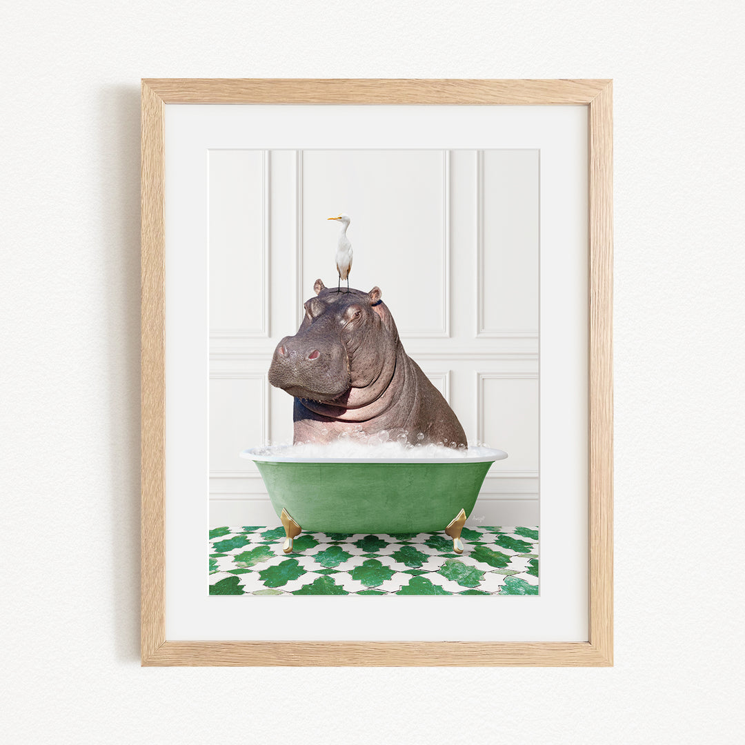 A framed image depicting a hippopotamus sitting in a green bathtub, with a seagull perched on its head.