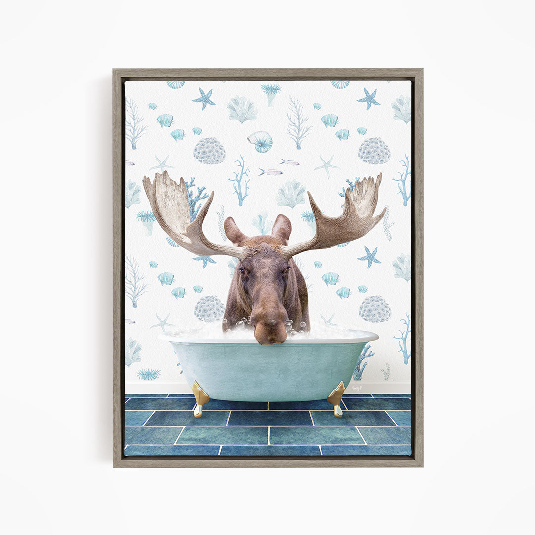 A moose with large antlers is sitting in a bathtub filled with water, surrounded by a pattern of blue and white seashells and starfish.