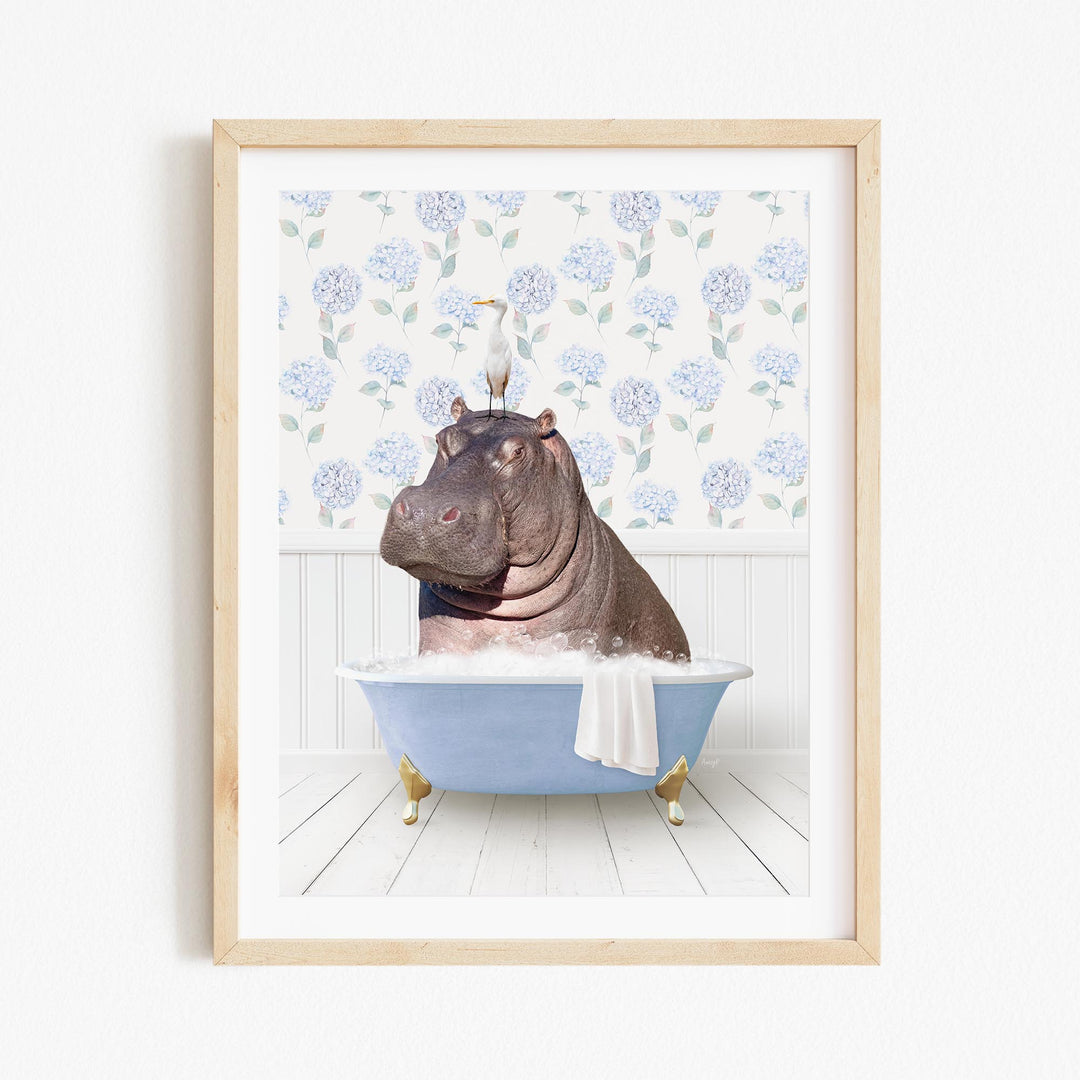 A framed image depicting a hippopotamus sitting in a bathtub, with a bird perched on its head.