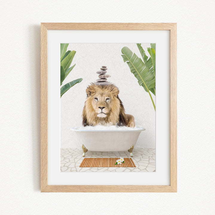A framed image depicting a lion sitting in a bathtub filled with water, surrounded by tropical plants.
