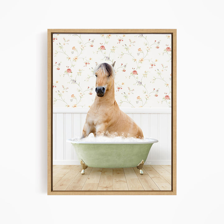 A light brown horse is sitting in a green bathtub filled with water, surrounded by a floral wallpaper.