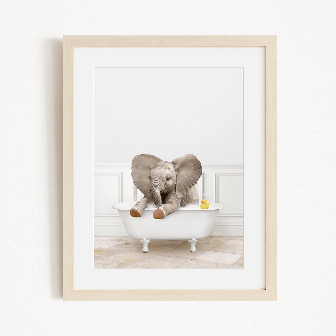 A baby elephant sitting in a white bathtub, with a yellow rubber duck floating nearby.