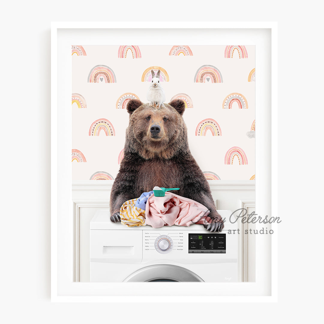 a brown bear sitting on top of a washing machine