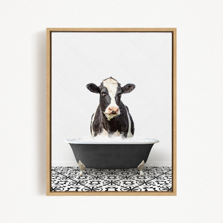 A black and white cow is standing in a black bathtub filled with water, creating a whimsical and playful scene.
