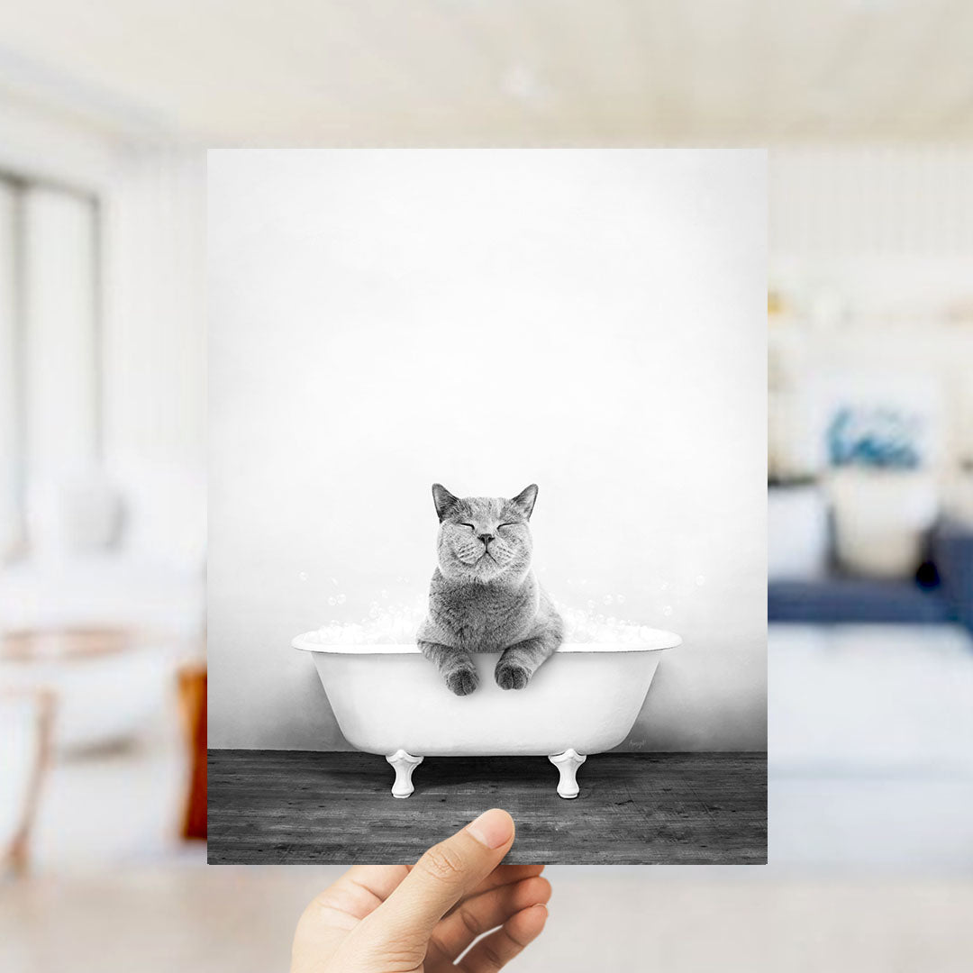 A gray cat sitting in a white bathtub, with its eyes closed, appears to be enjoying a relaxing bath.