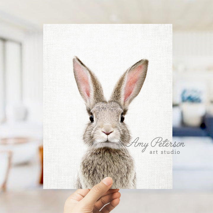 a person holding up a card with a picture of a rabbit