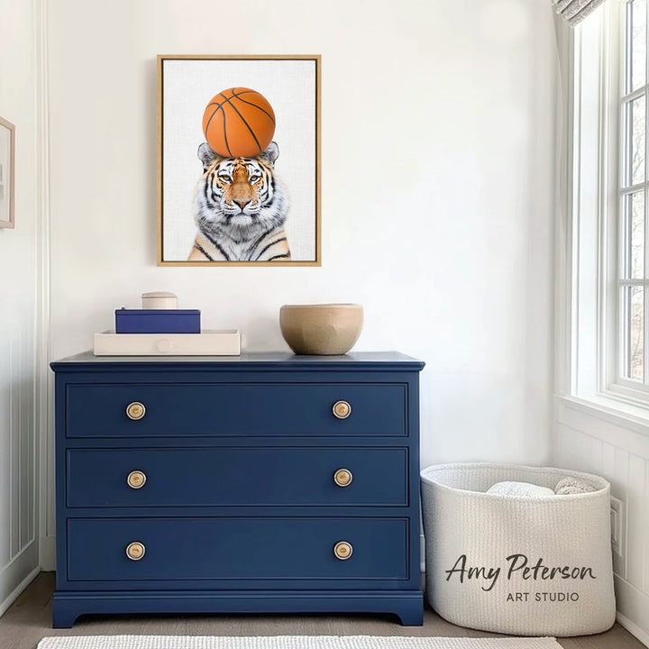 a blue dresser with a framed picture of a tiger wearing a basketball on top of it. The dresser is situated in a room with a window and a basket.