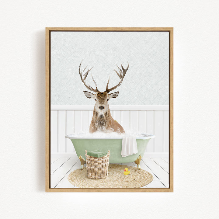 A deer with large antlers is sitting in a green bathtub filled with bubbles, surrounded by a basket and a yellow rubber duck.