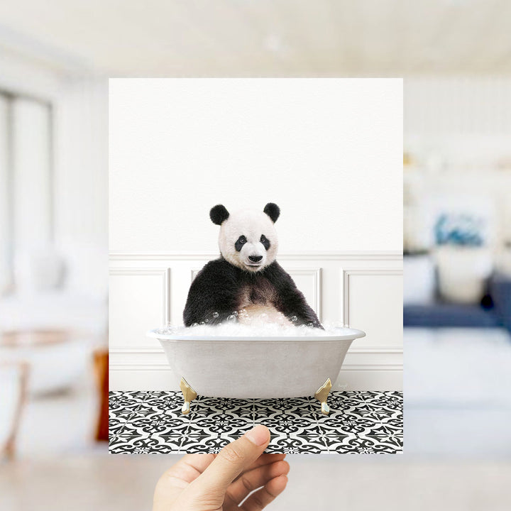 A panda bear sitting in a bathtub filled with bubbles, surrounded by a black and white patterned floor.