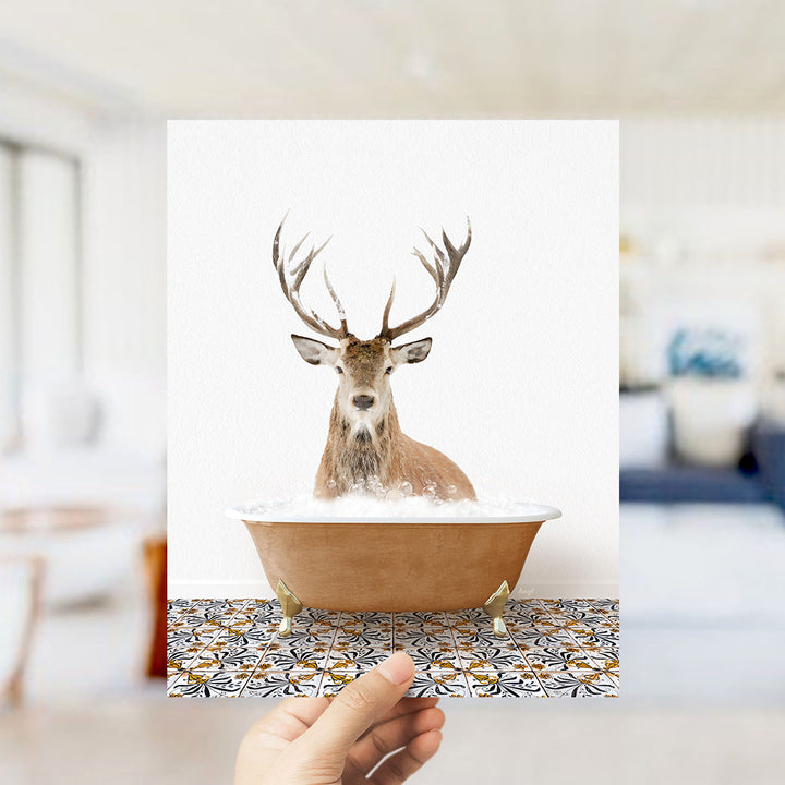 A deer with large antlers is sitting in a bathtub filled with water, creating a whimsical and unexpected scene.